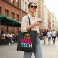 Black tote bag with colorful text 'Tip Your Nail Tech' on a white background