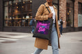 Black tote bag with 'Press On Sis' neon-style text design on a white background