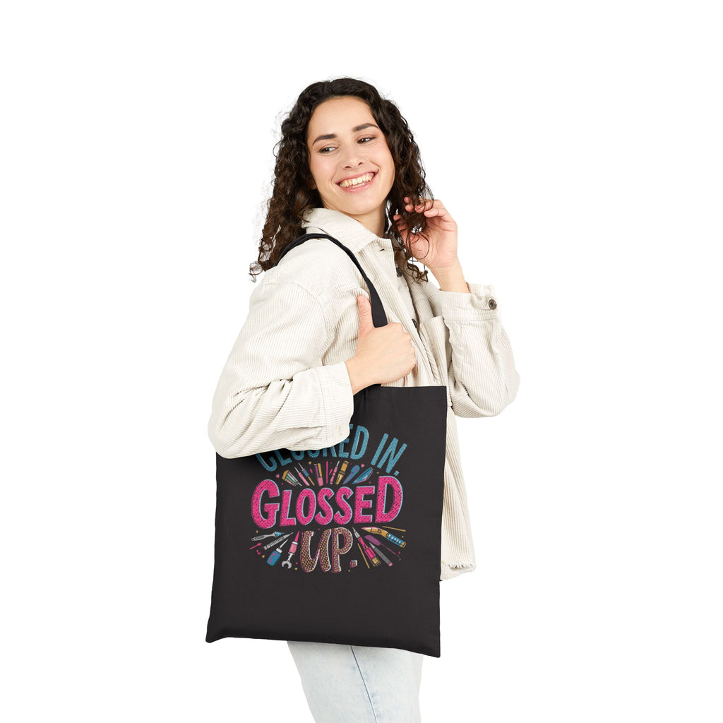 Woman holding a black tote bag with a book design and text on a white background