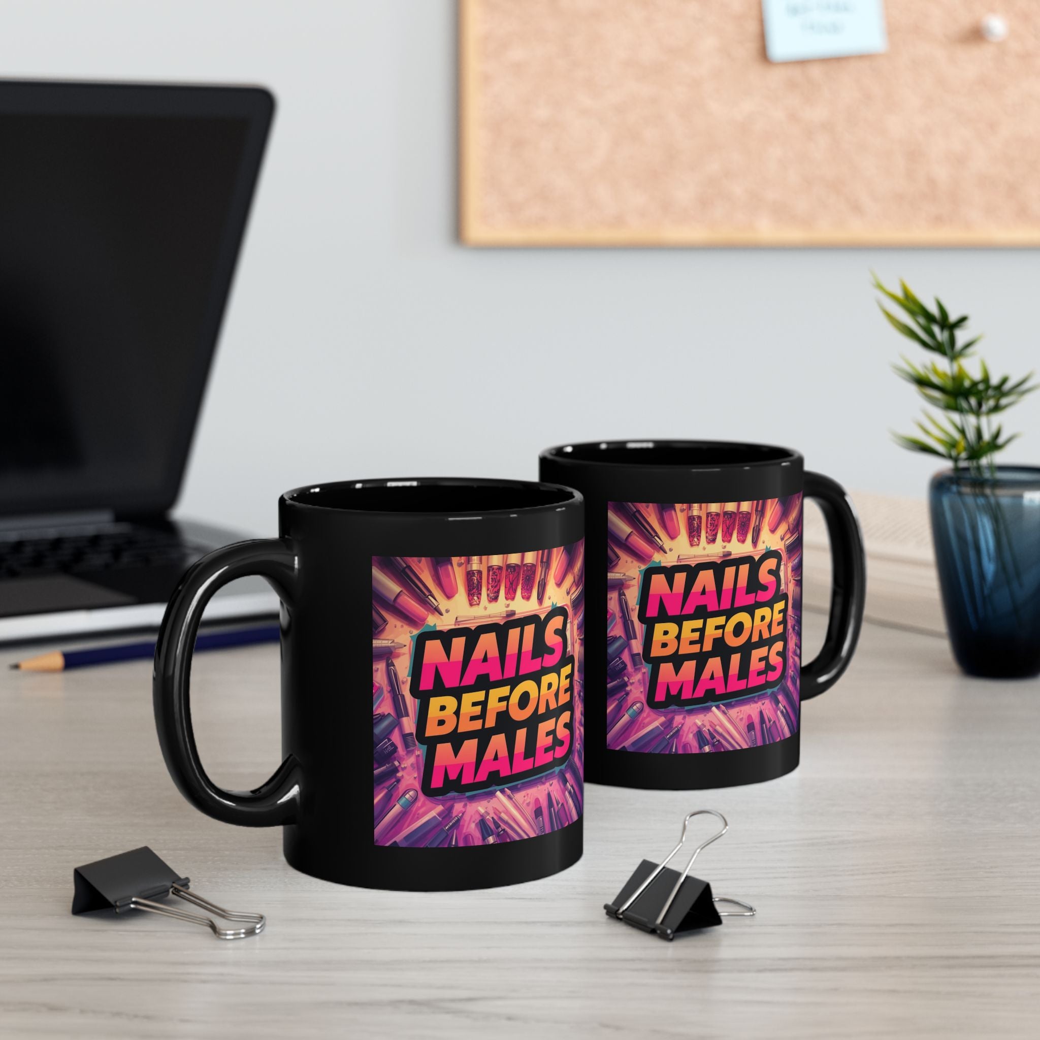 Two black mugs with colorful text design on a desk with office items.