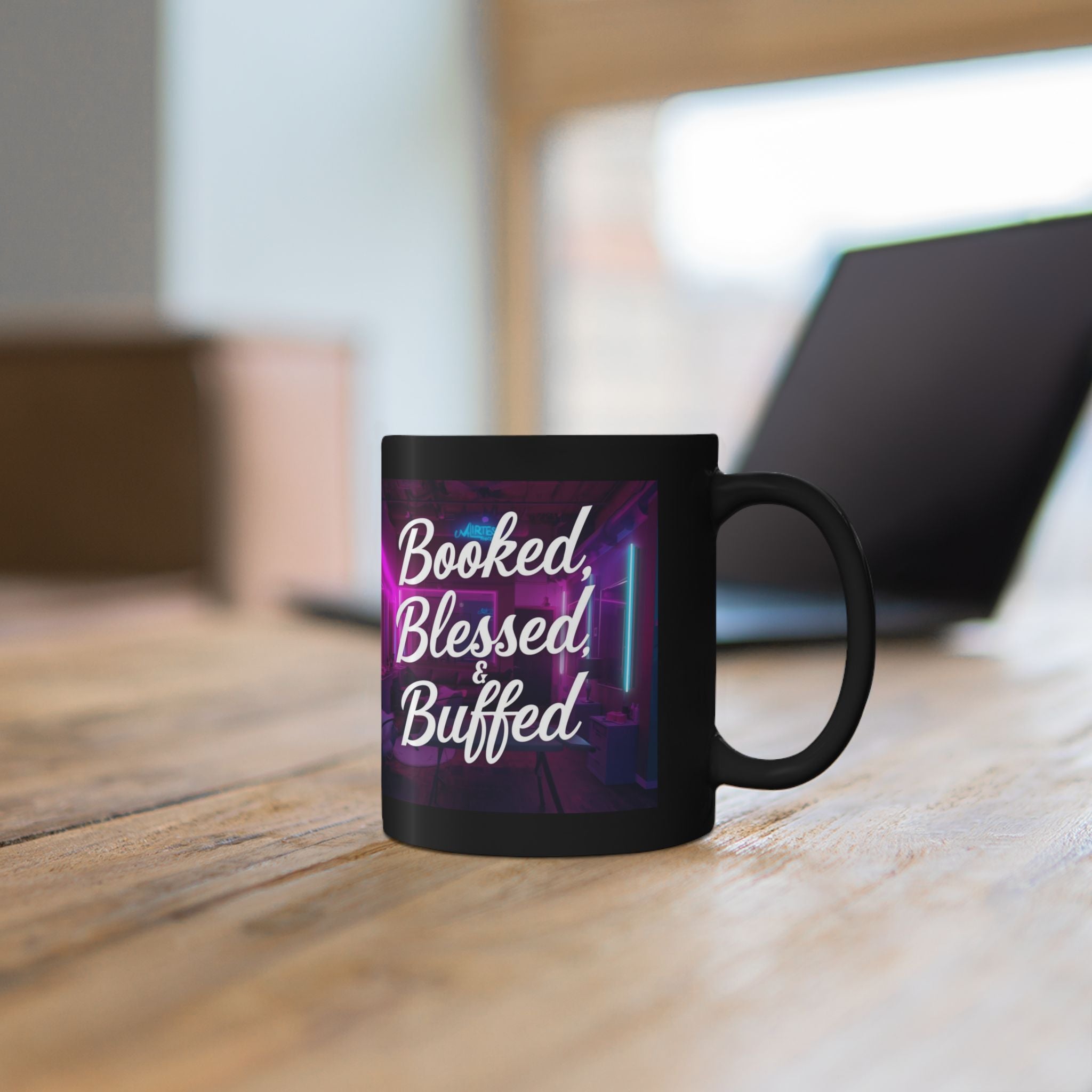 Black mug with 'Booked, Blessed, Buffed' text on a wooden surface