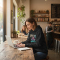 Black hoodie with 'PRESS ON, SIS' text in colorful letters on a white background