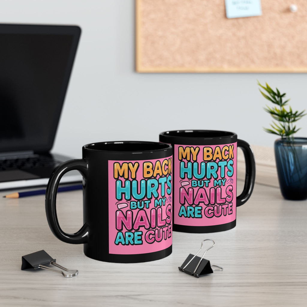 Two black mugs with colorful text on a desk with office items.