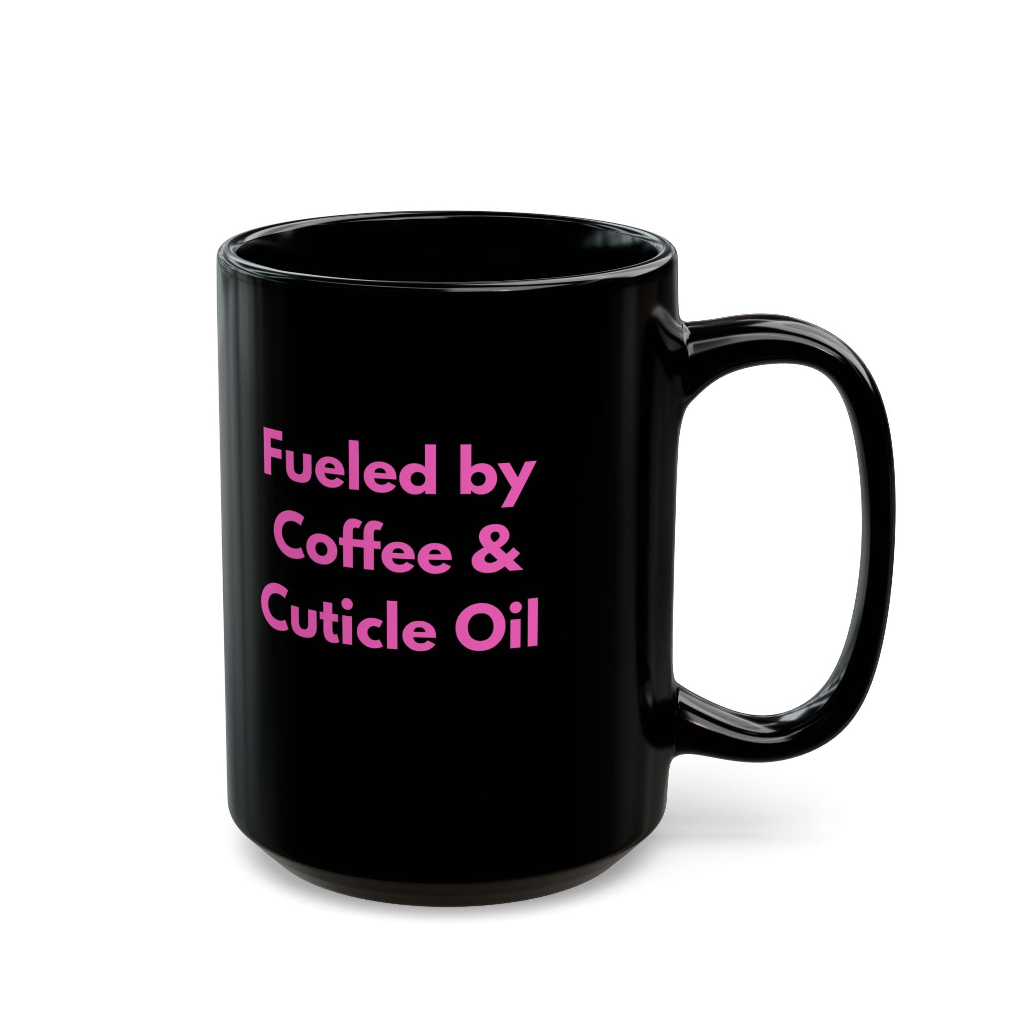 Black mug with pink text 'Fueled by Coffee & Cuticle Oil' on a white background