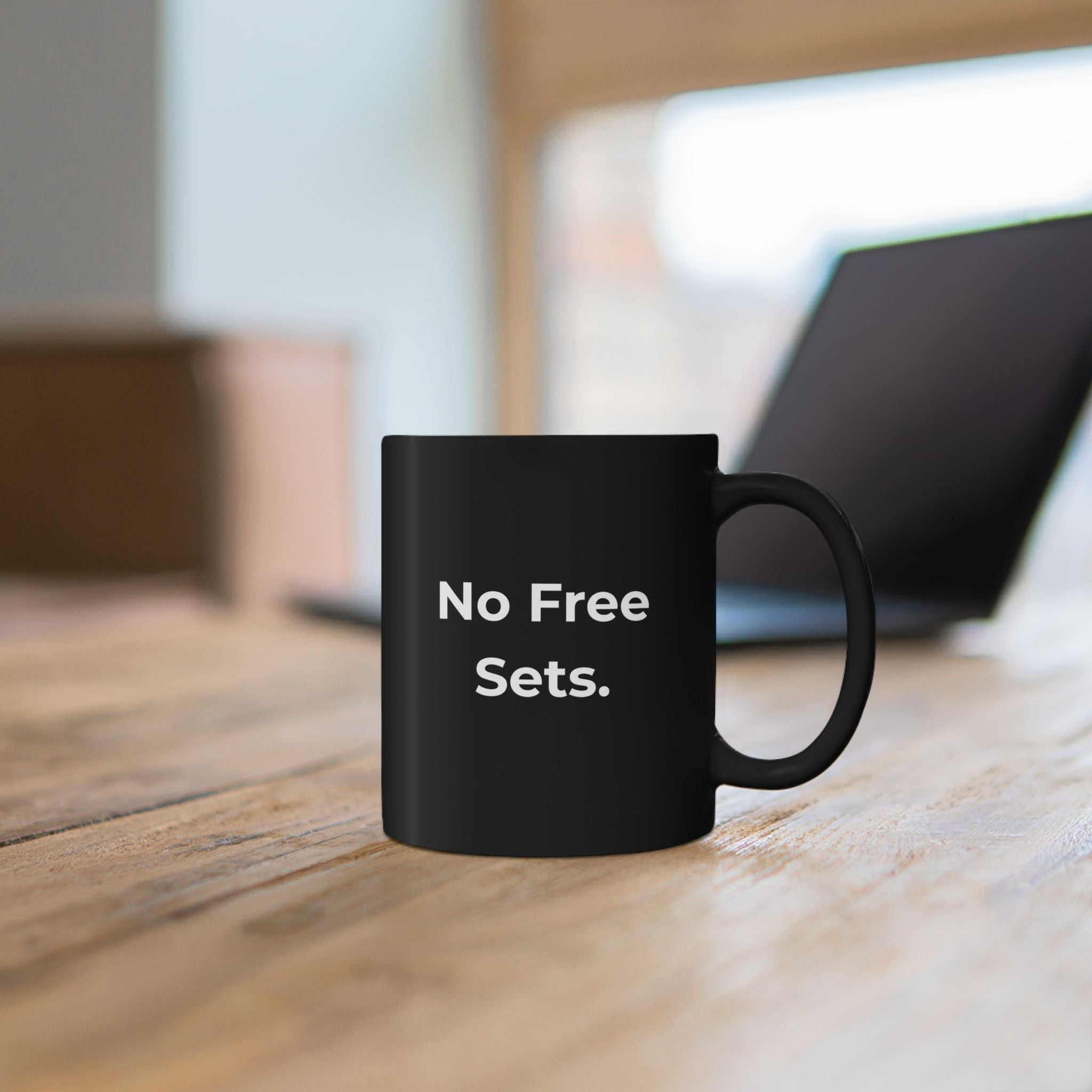 Black mug with library-themed design on a wooden surface